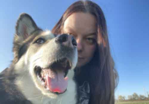 Frau mit Hund schauen direkt in die Kamera, das Bild hat eine unzureichende Auflösung es sieht verschwommen und unscharf aus